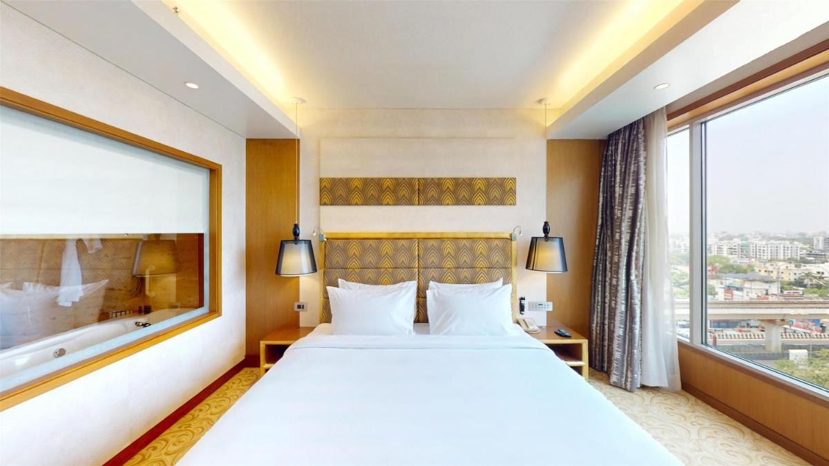 a bedroom with a large bed and a large window at Radisson Blu Hotel, Nagpur in Nagpur