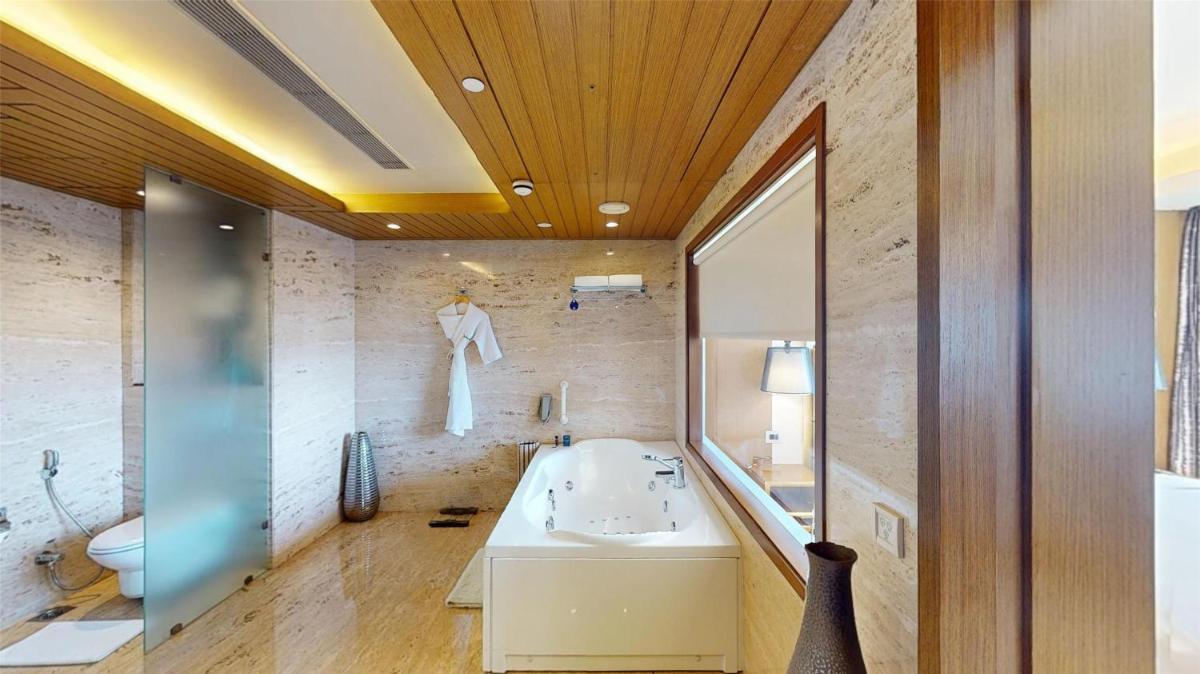 a bathroom with a tub and a sink and a toilet at Radisson Blu Hotel, Nagpur in Nagpur
