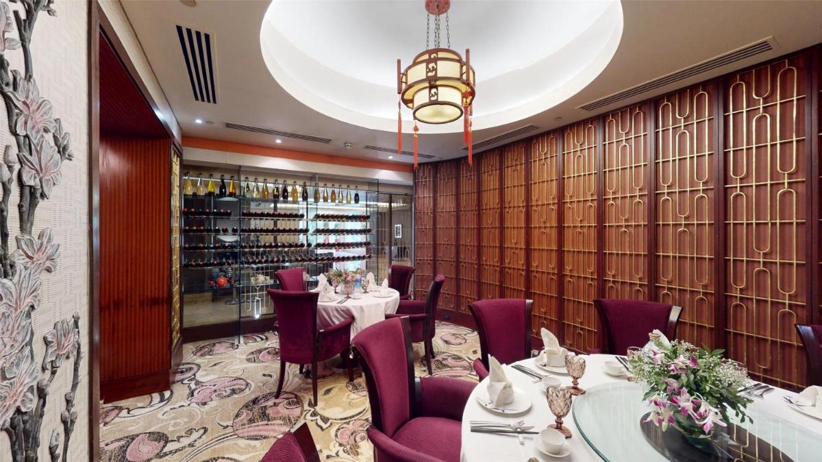 a restaurant with tables and chairs and a wine cellar at Radisson Blu Hotel, Nagpur in Nagpur