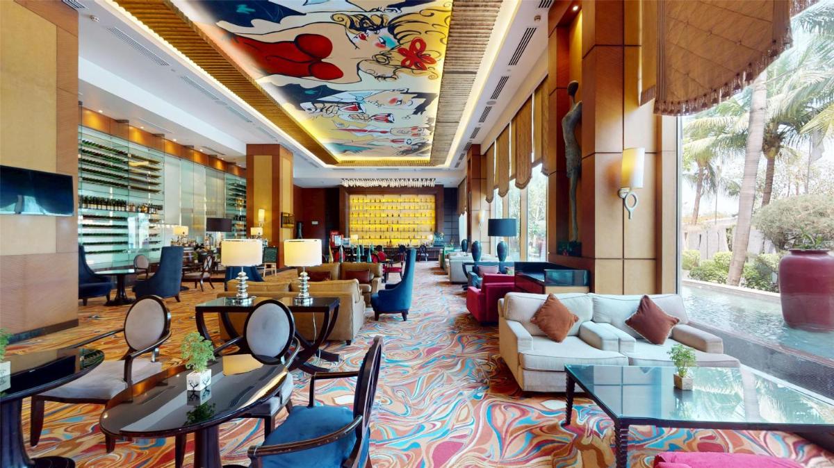 a lobby of a hotel with tables and chairs at Radisson Blu Hotel, Nagpur in Nagpur