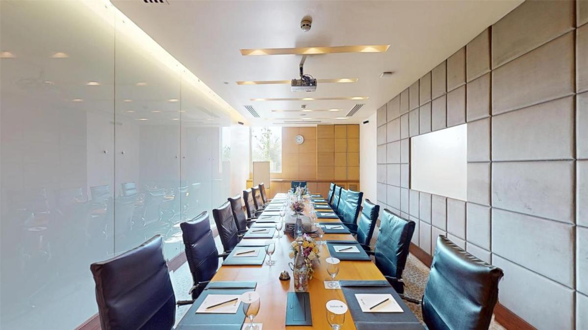 a long room with a long table and chairs at Radisson Blu Hotel, Nagpur in Nagpur