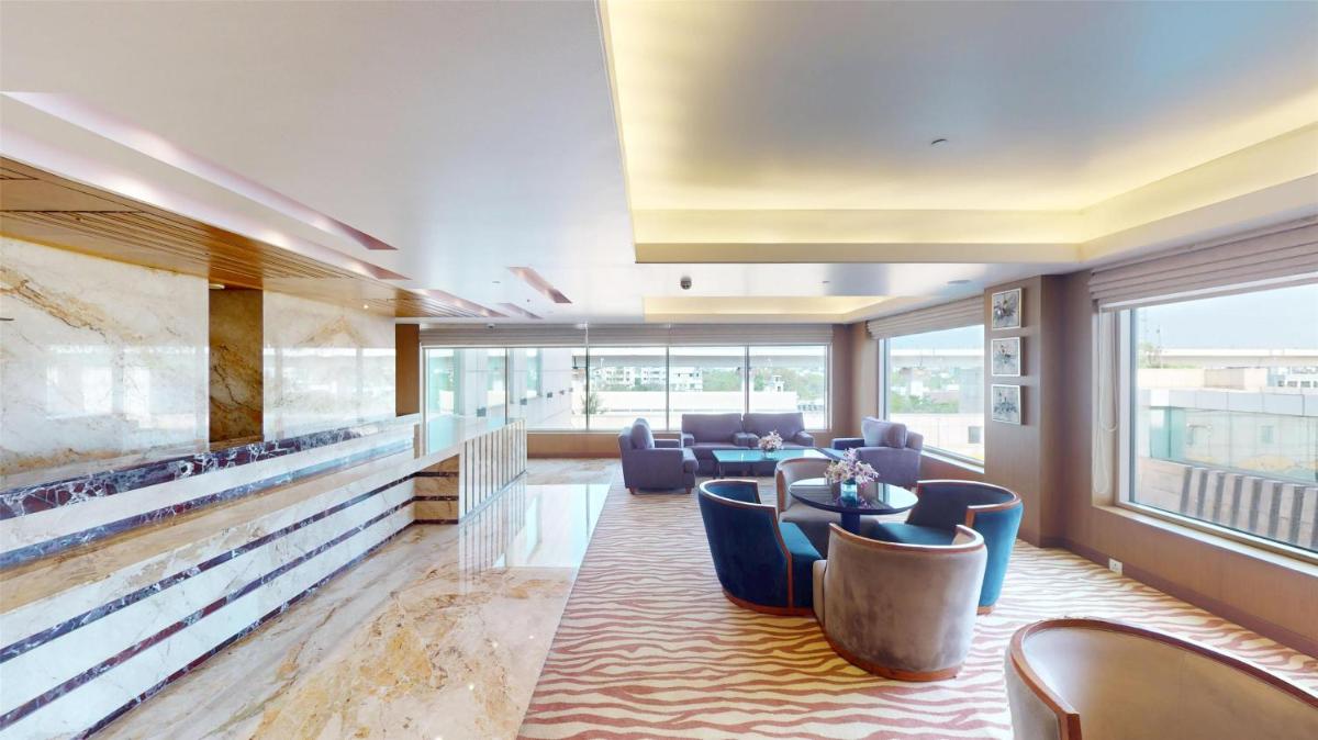 a lobby with blue chairs and a large aquarium at Radisson Blu Hotel, Nagpur in Nagpur