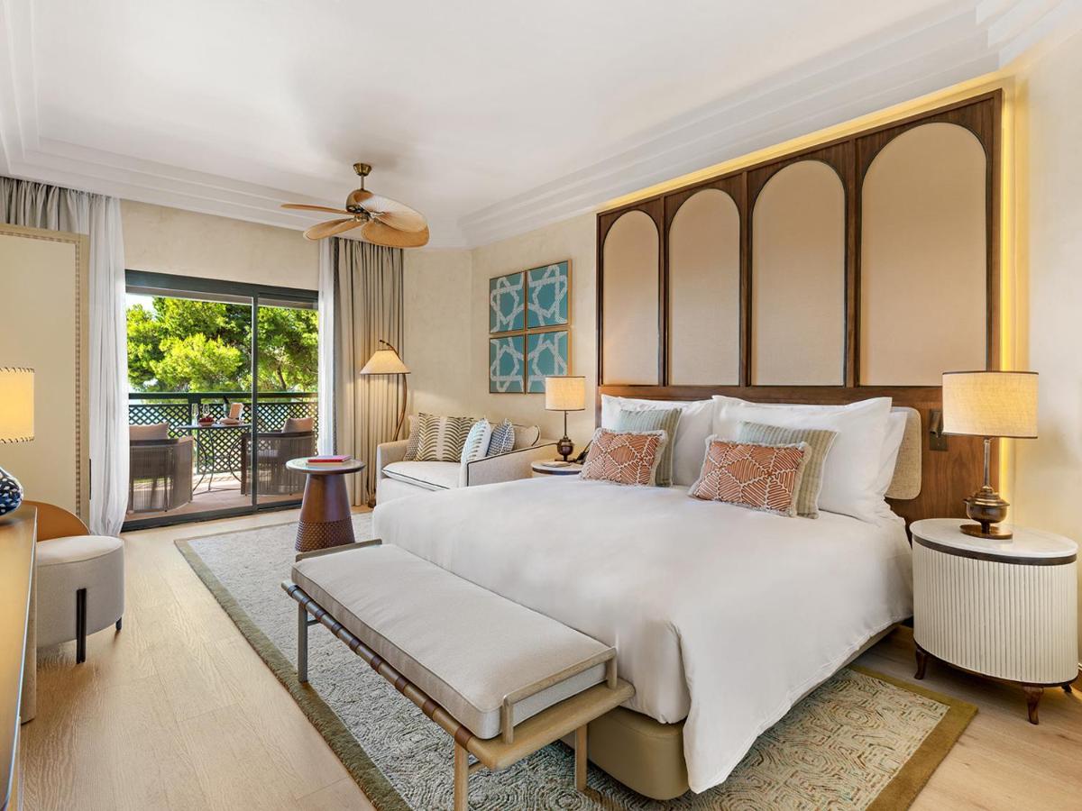 Un dormitorio con una gran cama blanca y una sala de estar. en Gran Marbella Resort & Beach Club, en Marbella