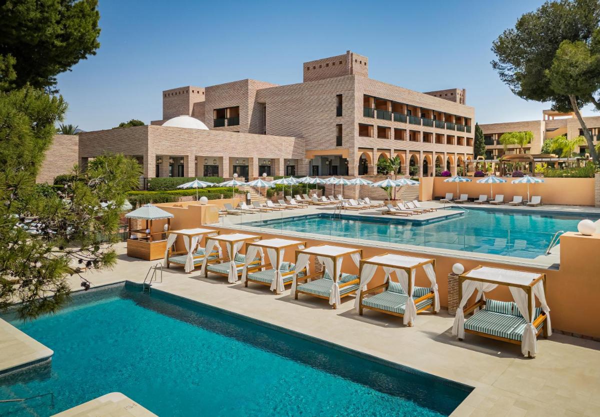 Una piscina con sillas y un hotel. en Gran Marbella Resort & Beach Club, en Marbella