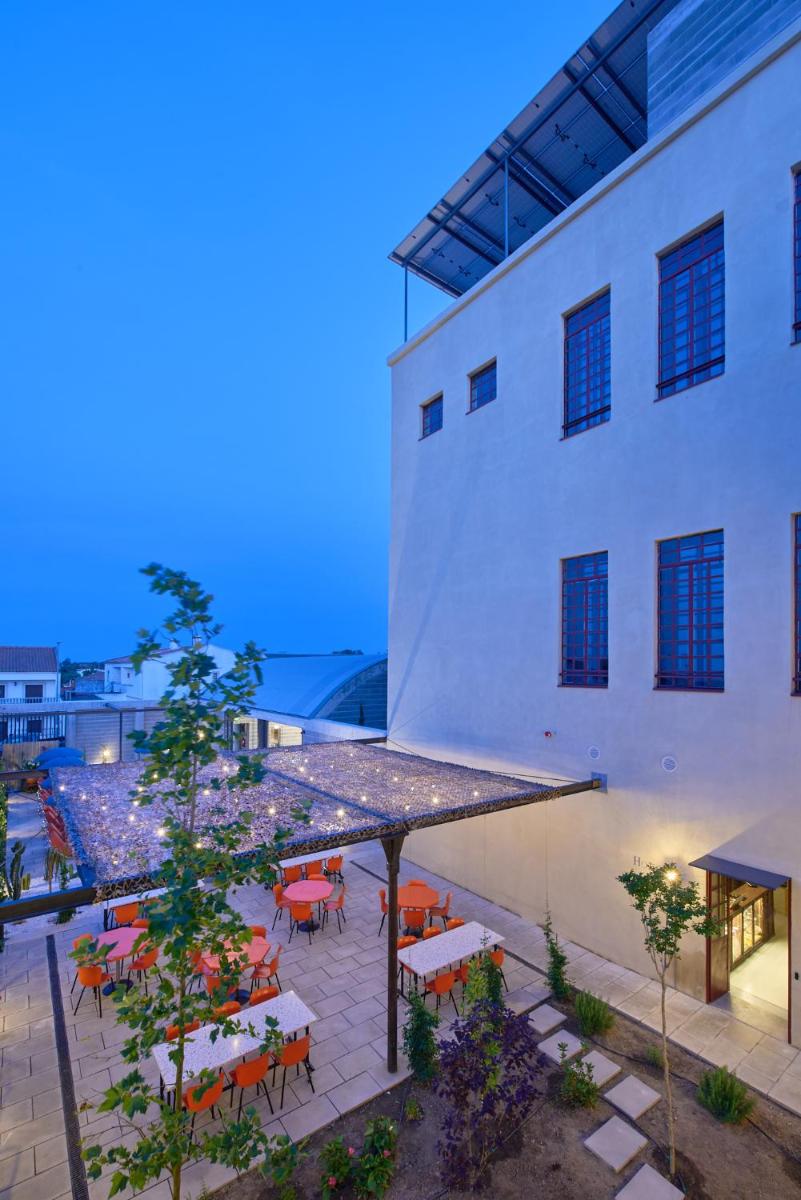 um pátio exterior com mesas e cadeiras ao lado de um edifício em Moagem Industrial Lodge em Viana do Alentejo
