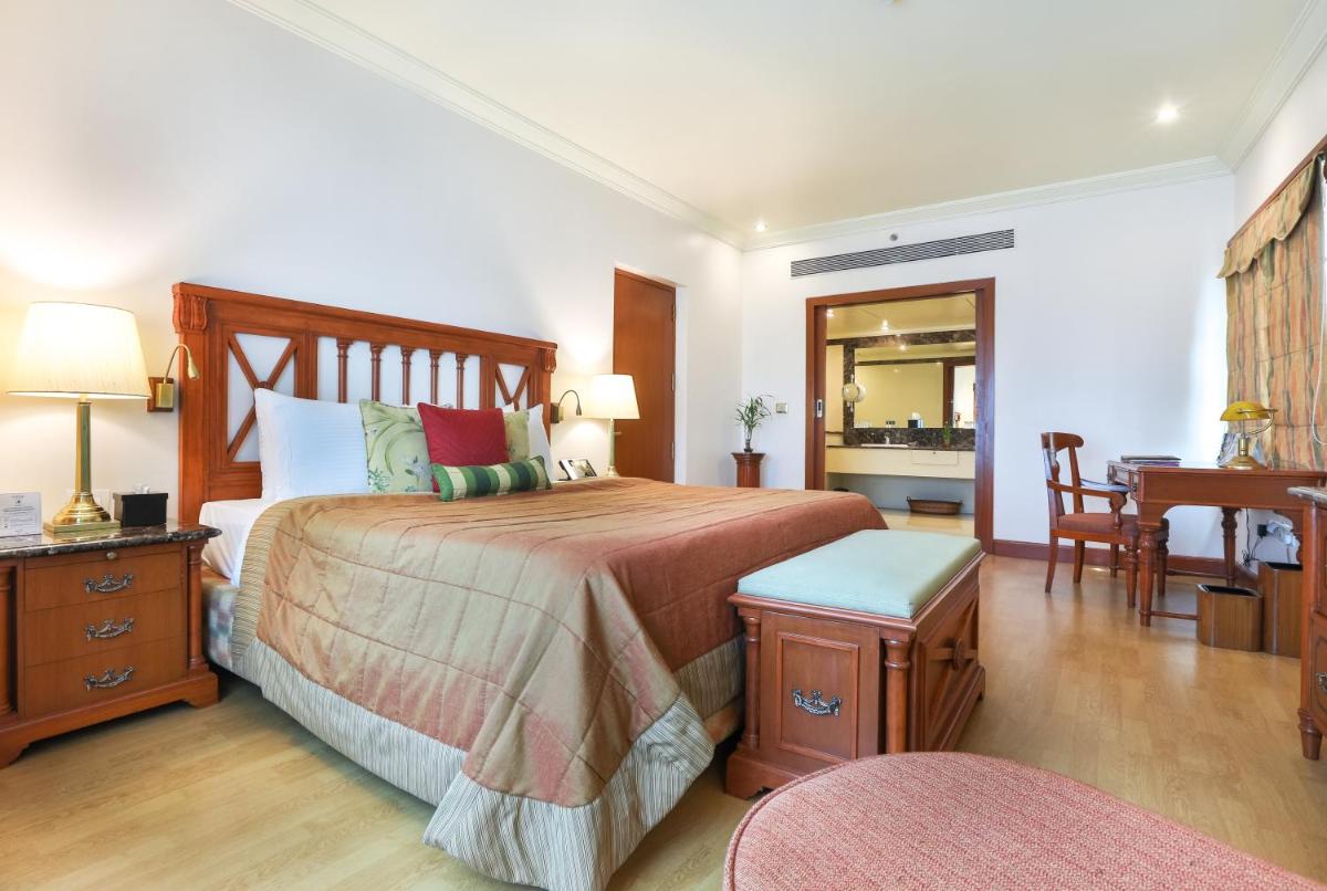 a bedroom with a bed and a table and a desk at The Orchid Hotel Mumbai Vile Parle in Mumbai