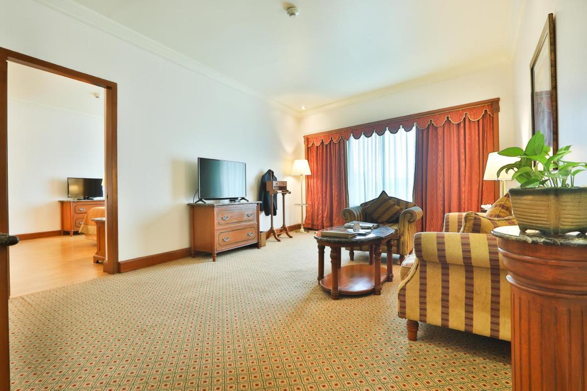 a living room with a couch and a tv at The Orchid Hotel Mumbai Vile Parle in Mumbai