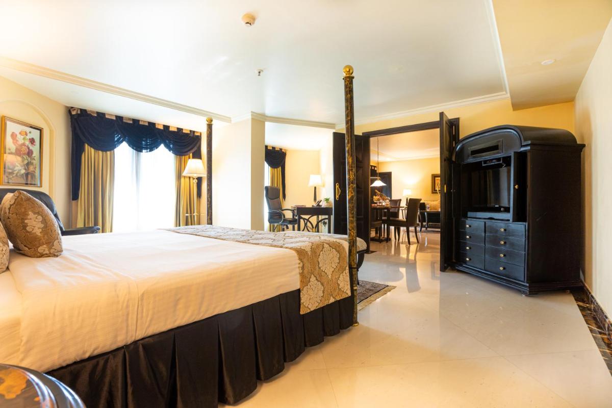 a bedroom with a large bed and a dining room at The Orchid Hotel Mumbai Vile Parle in Mumbai