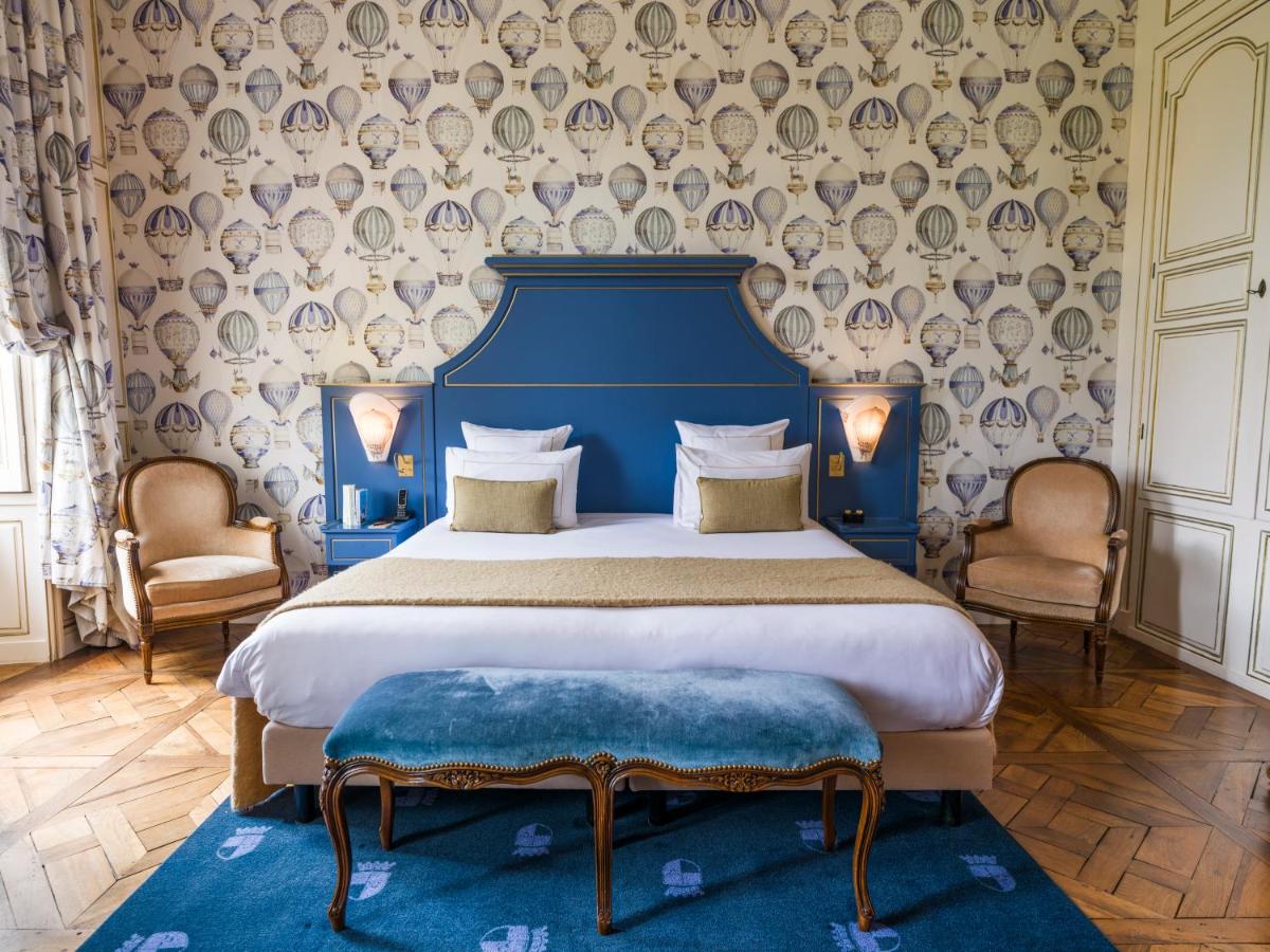 une chambre avec un lit avec une tête de lit bleue dans l'établissement Chateau d'Audrieu, à Audrieu