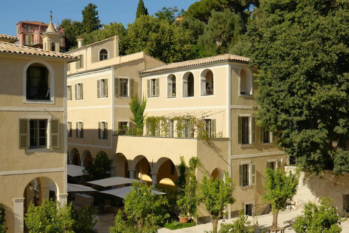 une image d'un bâtiment avec des arbres devant lui dans l'établissement Hôtel du Couvent, a Luxury Collection Hotel, Nice, à Nice