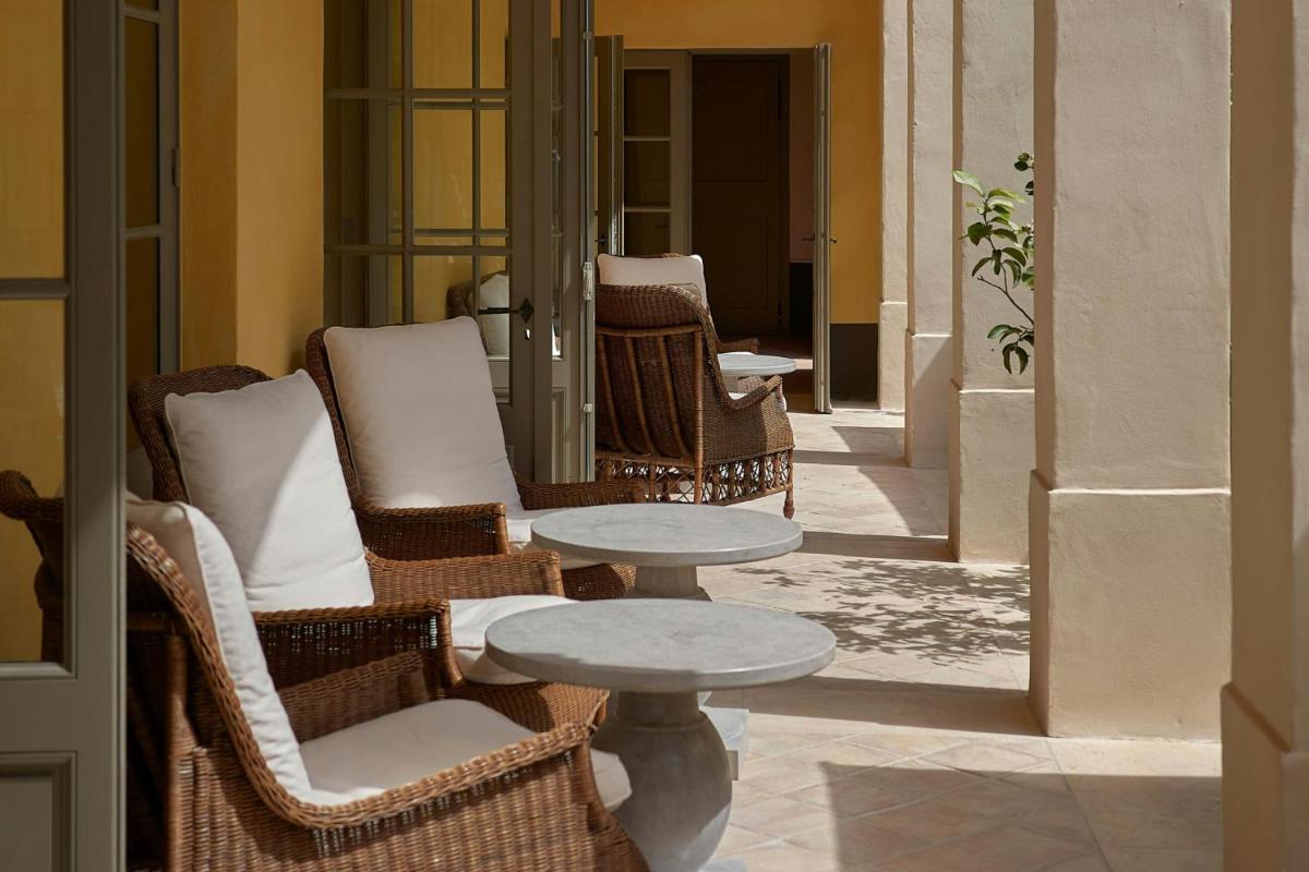 d'une terrasse avec des chaises en osier, une table et une table. dans l'établissement Hôtel du Couvent, a Luxury Collection Hotel, Nice, à Nice