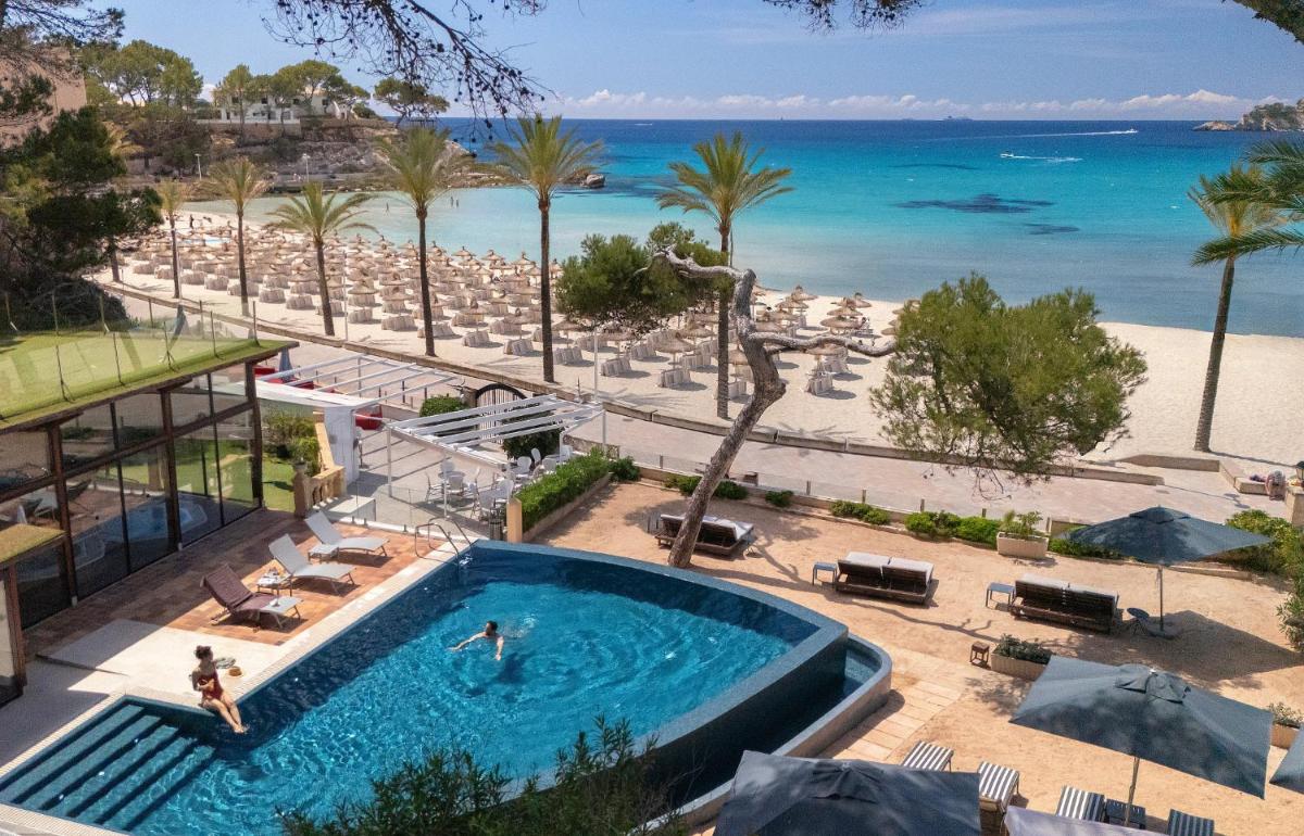 una piscina junto a una playa y el océano en Secrets Mallorca Villamil Resort & Spa - Adults Only (+18), en Paguera