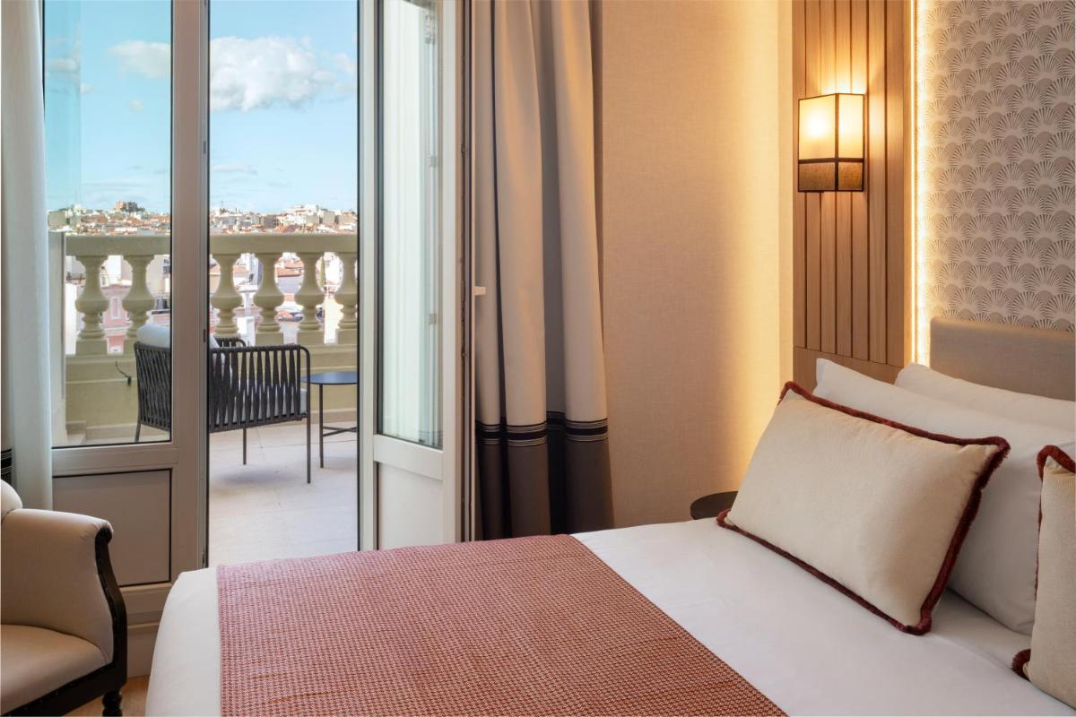 Un dormitorio con una cama y vista a un balcón. en Catalonia Plaza España Hotel & Spa, en Madrid