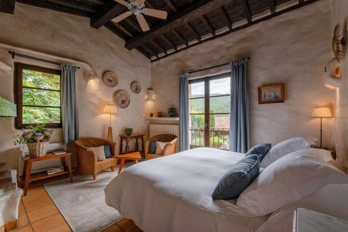une chambre avec un grand lit blanc dans une pièce dans l'établissement Château De Riell, à Molitg-les-Bains 45 autres photos