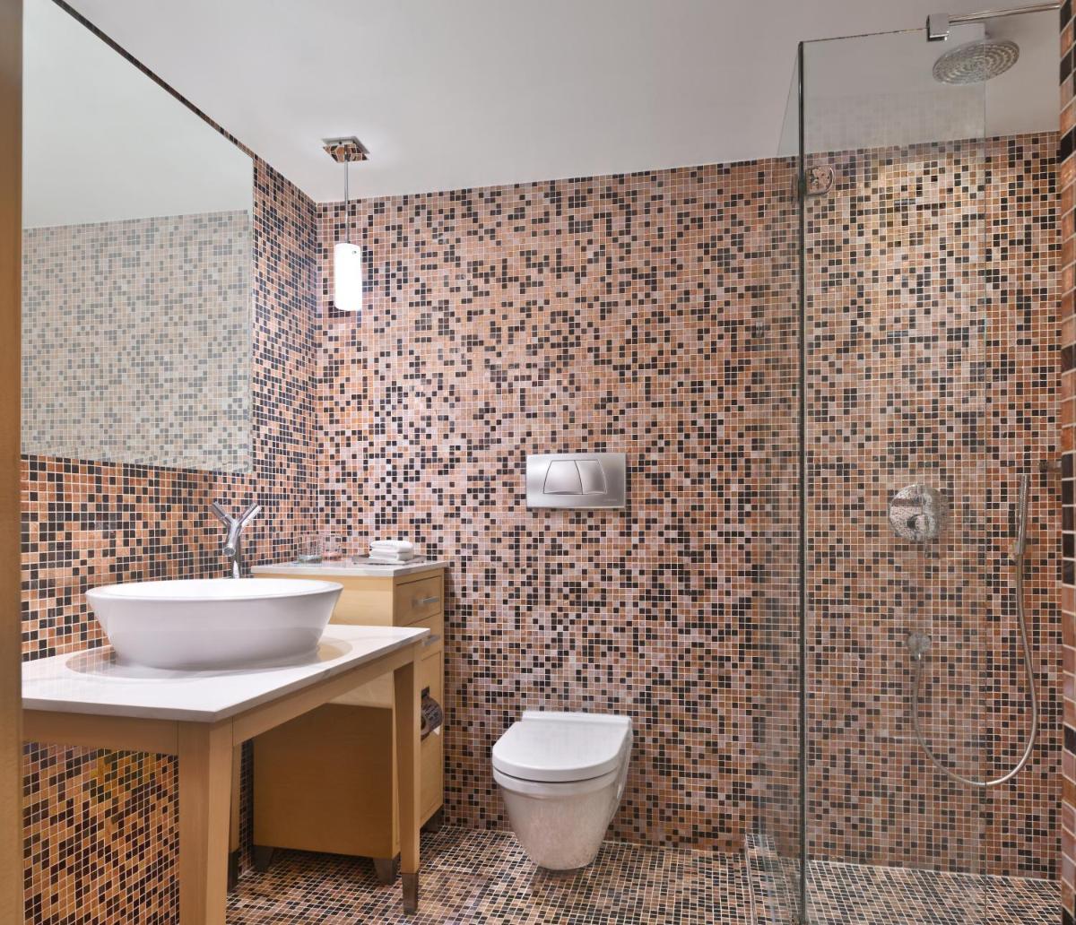 a bathroom with a toilet and a sink and a shower at Le Meridien New Delhi in New Delhi a bathroom with a toilet and a sink and a shower at Le Meridien New Delhi in New Delhi