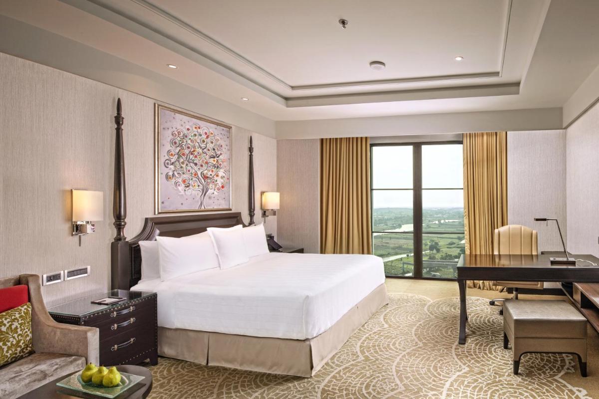 a bedroom with a bed and a desk and a piano at ITC Royal Bengal, a Luxury Collection Hotel, Kolkata in Kolkata