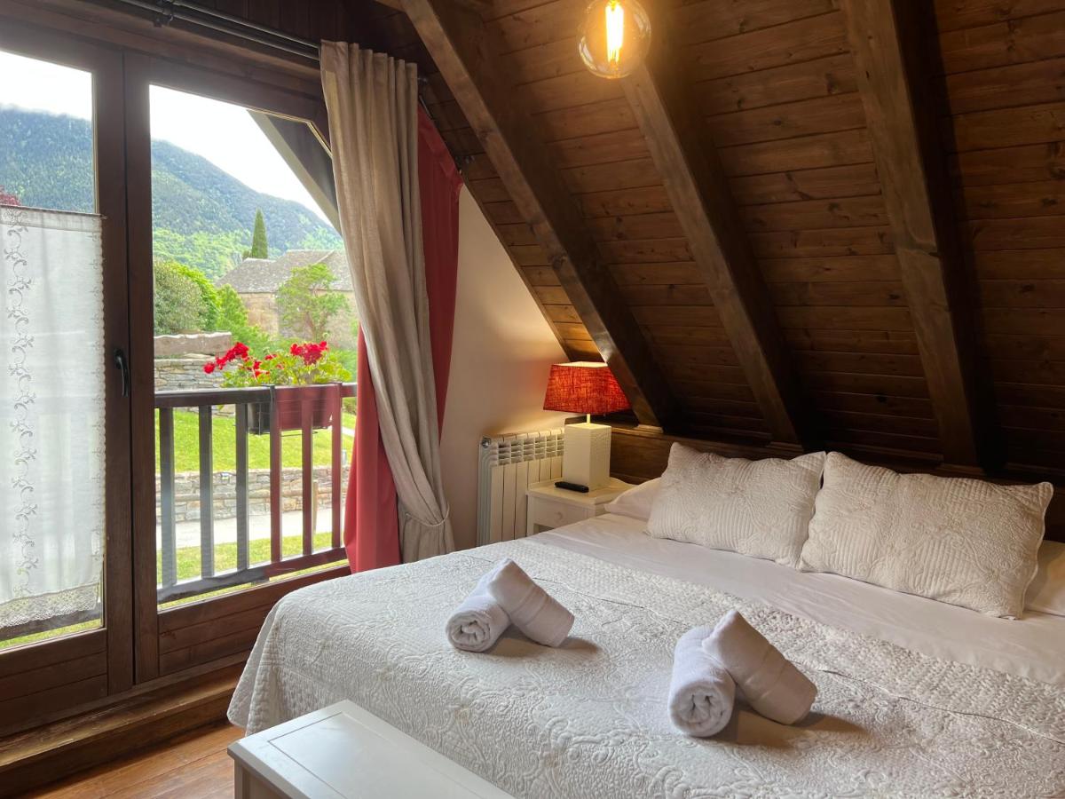 Un dormitorio con una cama y una ventana grande. en Tierras De Arán, en Betlán