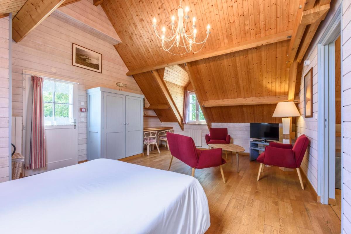 une chambre avec un lit et des chaises dans une pièce dans l'établissement La Désirade - Hôtel, Spa & Restaurant, à Bangor