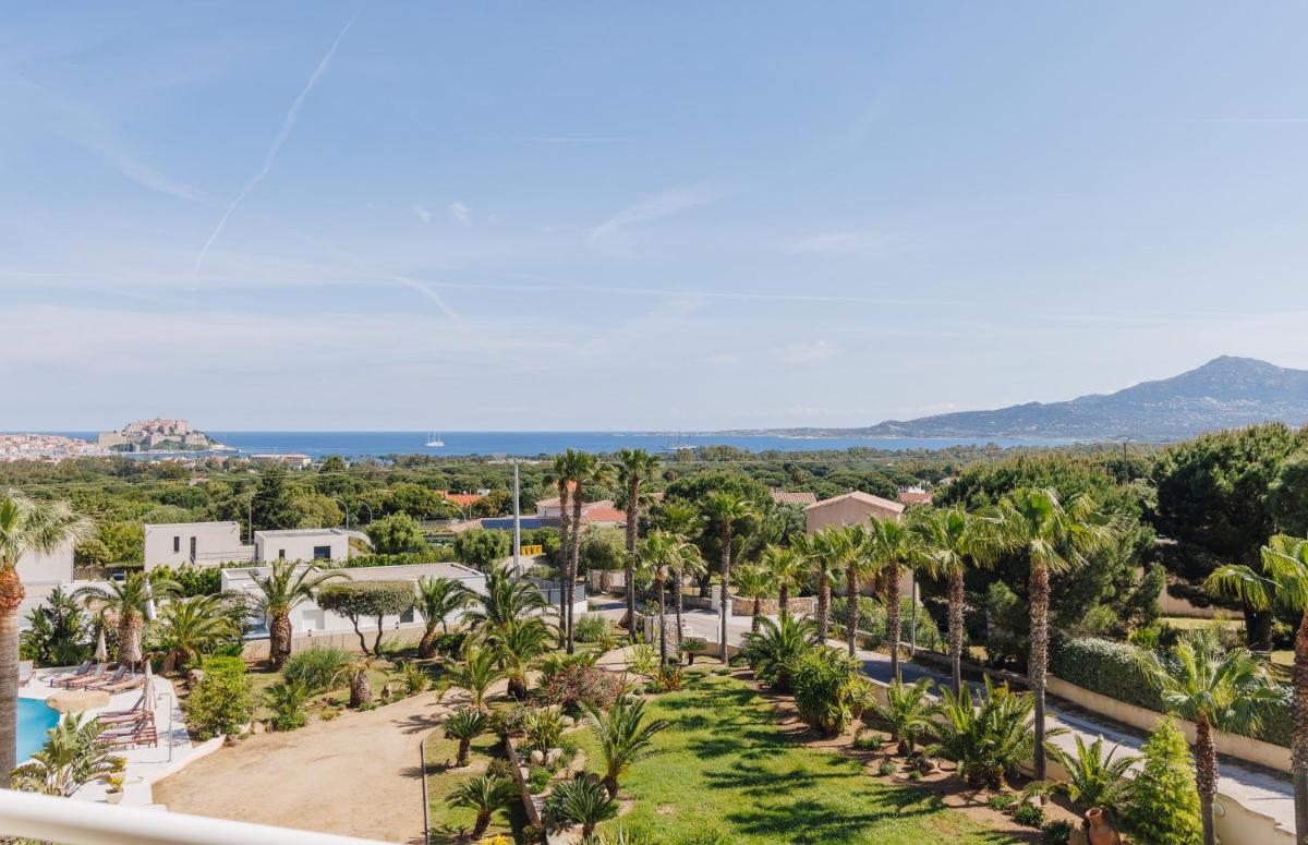 une vue aérienne d'un complexe hôtelier avec des palmiers dans l'établissement Hotel Corsica & Spa Serena, à Calvi une vue aérienne d'un complexe hôtelier avec des palmiers dans l'établissement Hotel Corsica & Spa Serena, à Calvi