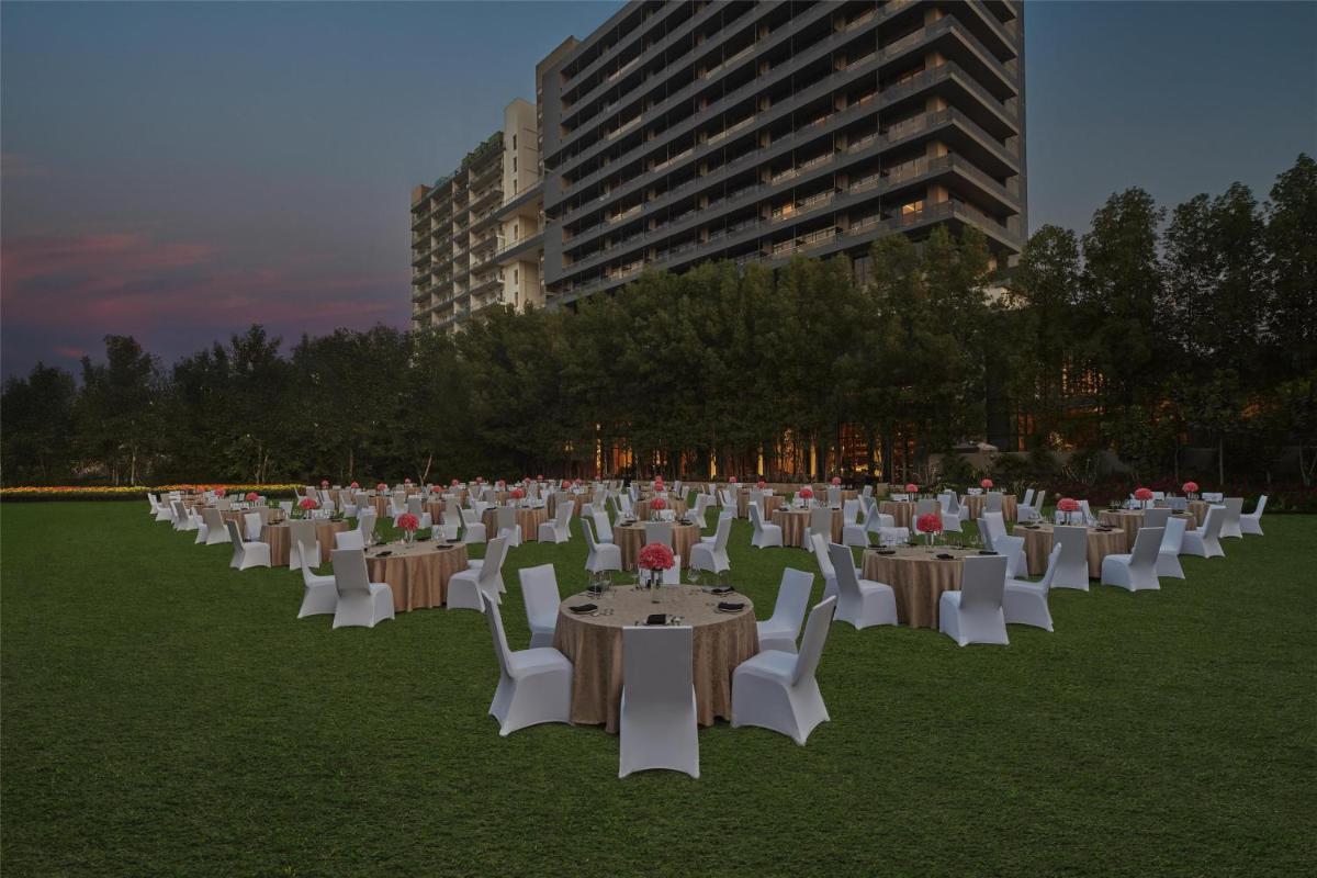 a group of tables and chairs in a field at Hilton Gurugram Baani City Centre in Gurgaon +59 photos