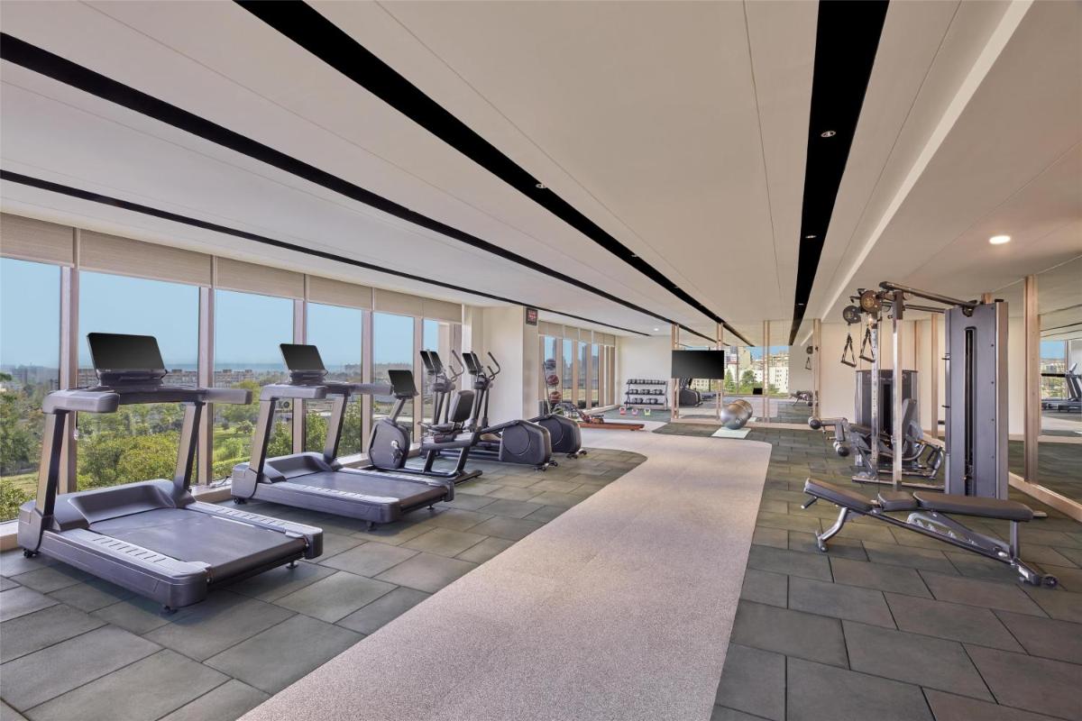 a gym with treadmills and exercise equipment in a building at Hilton Gurugram Baani City Centre in Gurgaon