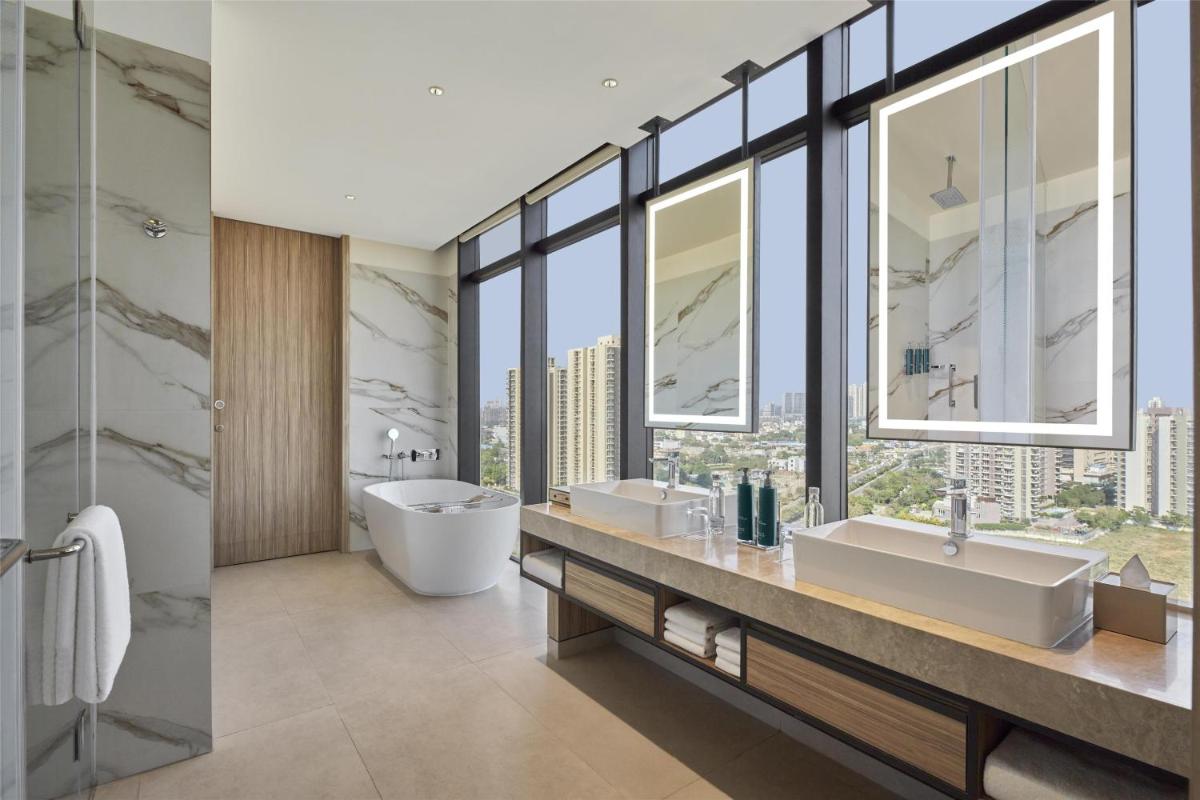 a bathroom with two sinks and a large window at Hilton Gurugram Baani City Centre in Gurgaon