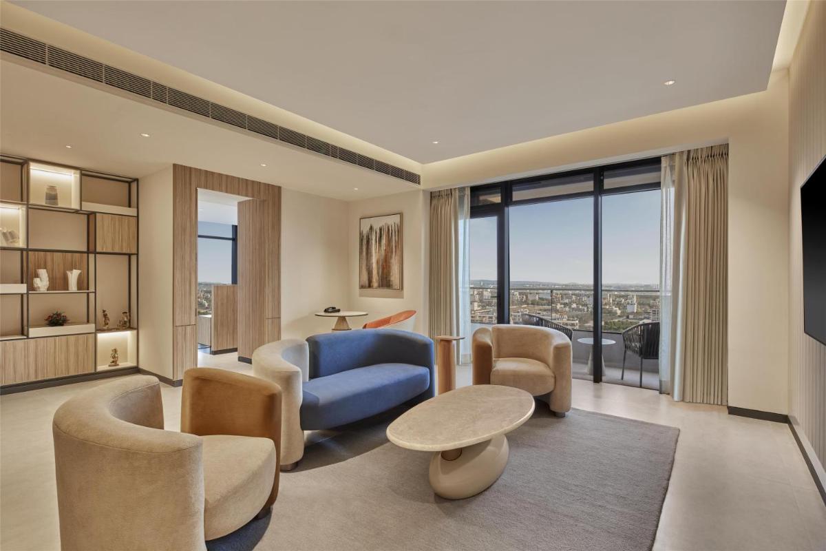 a living room with a blue couch and chairs at Hilton Gurugram Baani City Centre in Gurgaon