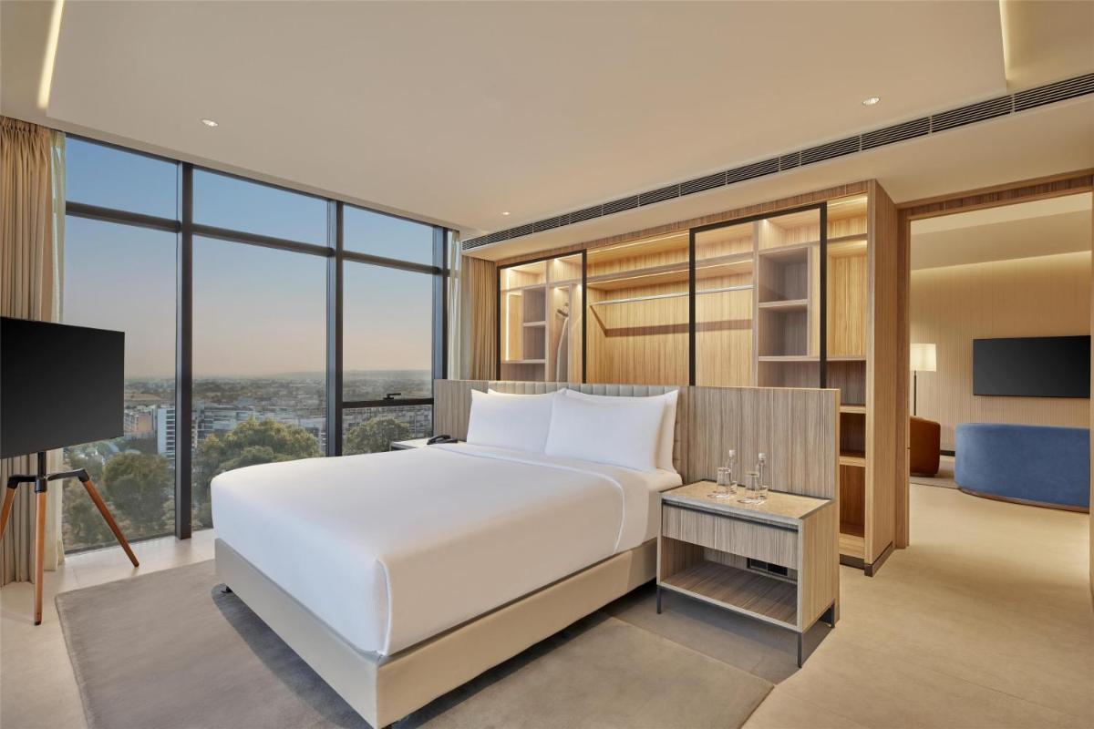a bedroom with a large white bed and a large window at Hilton Gurugram Baani City Centre in Gurgaon