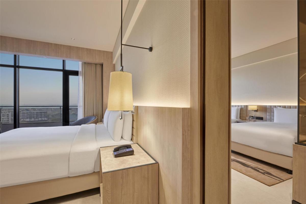 a hotel room with a bed and a window at Hilton Gurugram Baani City Centre in Gurgaon