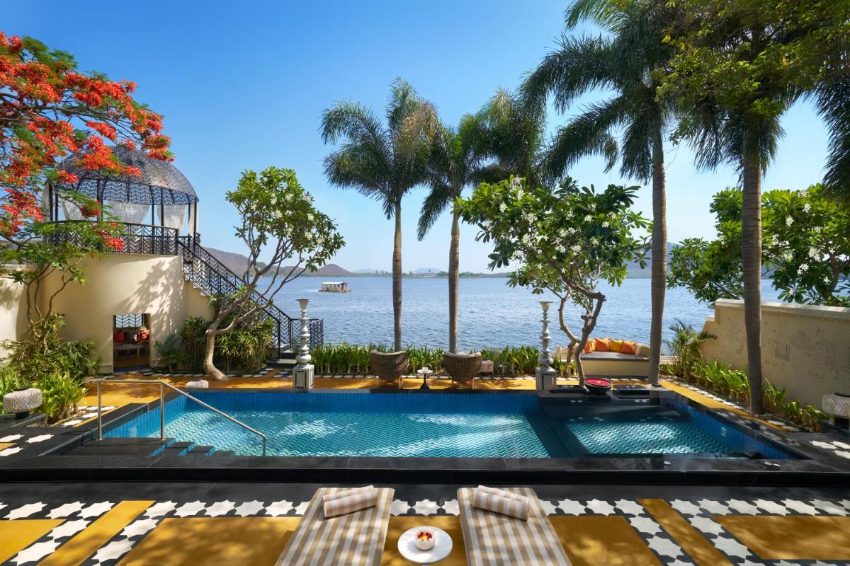 a swimming pool with a view of the ocean at The Leela Palace Udaipur in Udaipur