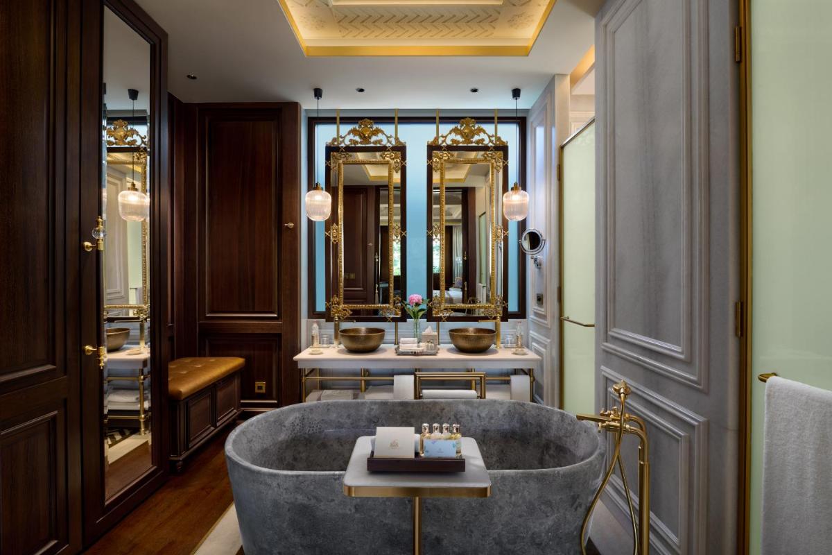 a bathroom with a tub and two sinks at The Leela Palace Udaipur in Udaipur