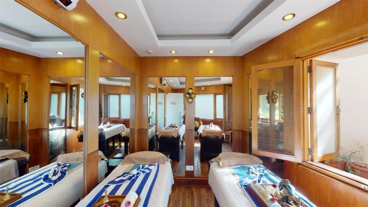 a room with two beds and mirrors in a boat at Radisson Hotel Shimla in Shimla