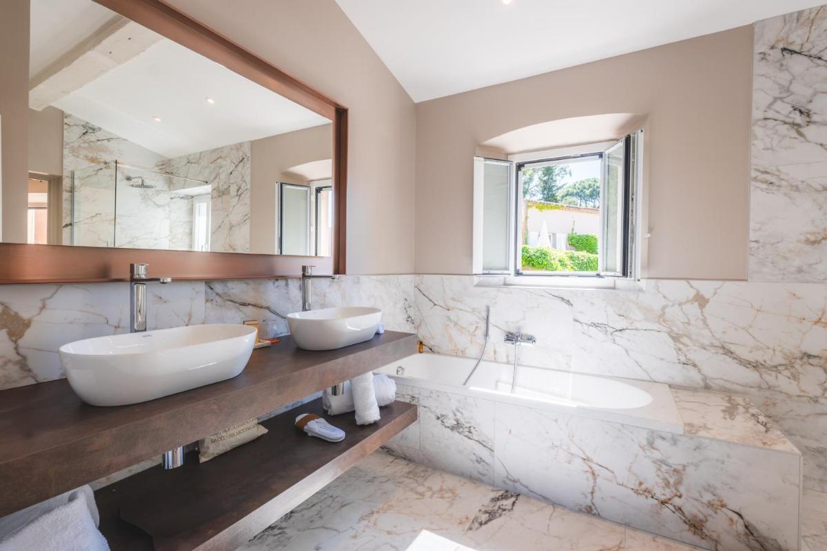 une salle de bain avec deux lavabos et un miroir dans l'établissement Hôtel La Mandarine, à Saint-Tropez une salle de bain avec deux lavabos et un miroir dans l'établissement Hôtel La Mandarine, à Saint-Tropez