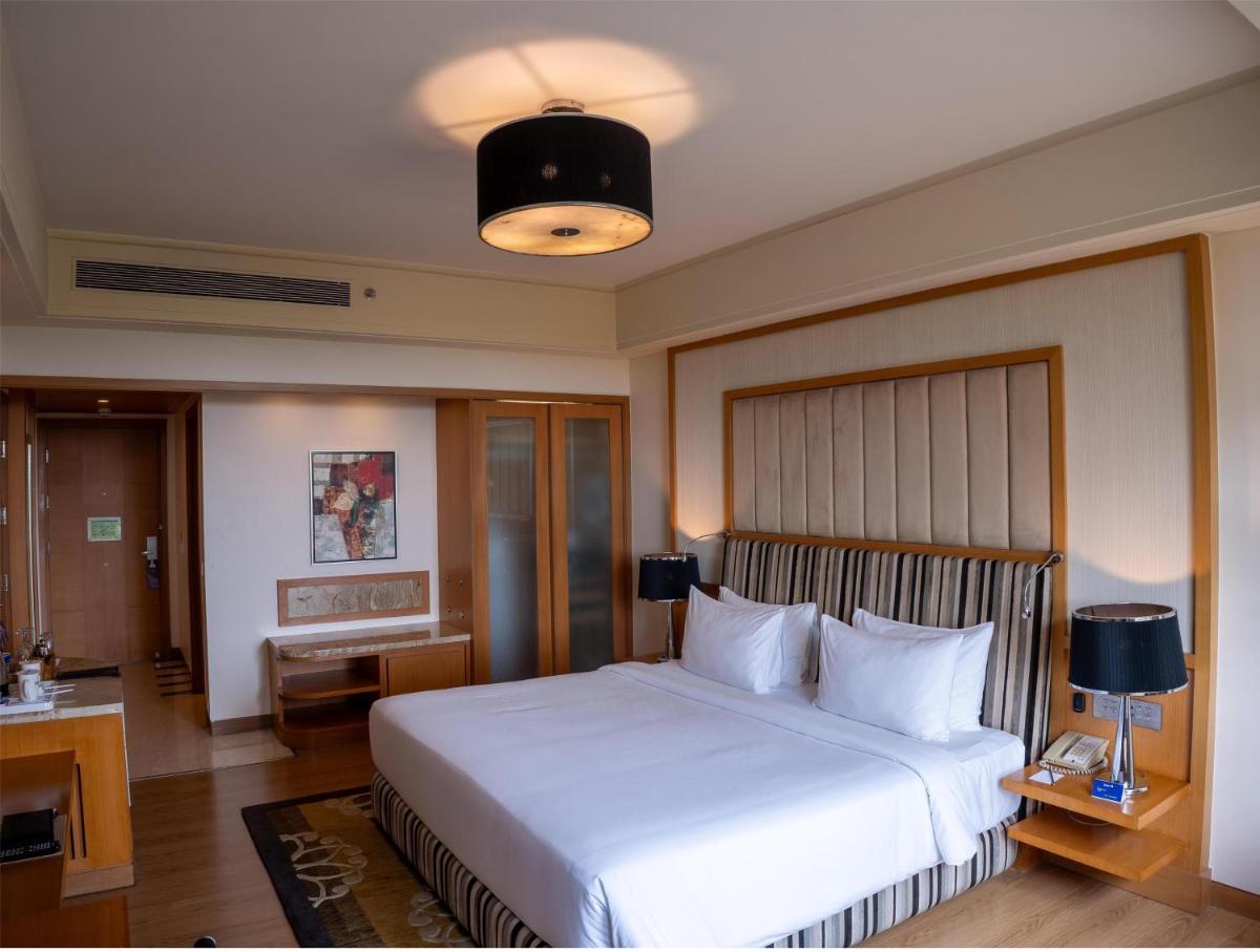 a bedroom with a large white bed in a room at Radisson Blu Hotel, Nagpur in Nagpur