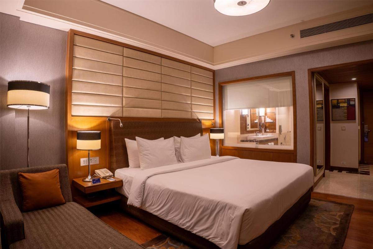 a hotel room with a bed and a chair at Radisson Blu Hotel, Nagpur in Nagpur