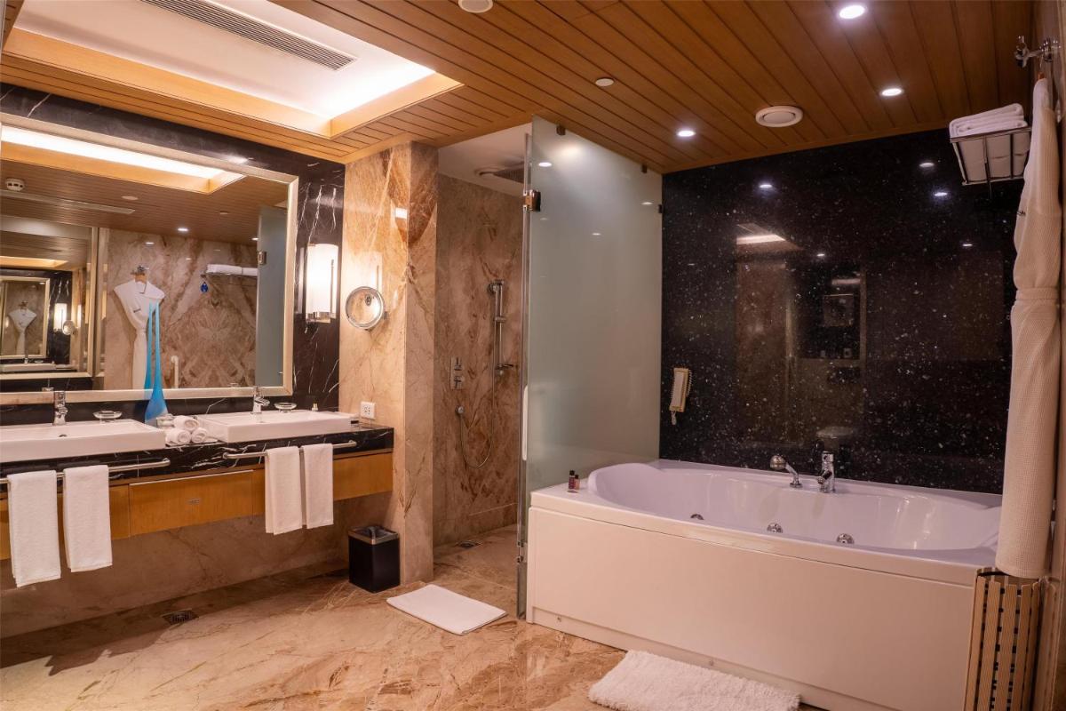 a large bathroom with two sinks and a tub at Radisson Blu Hotel, Nagpur in Nagpur