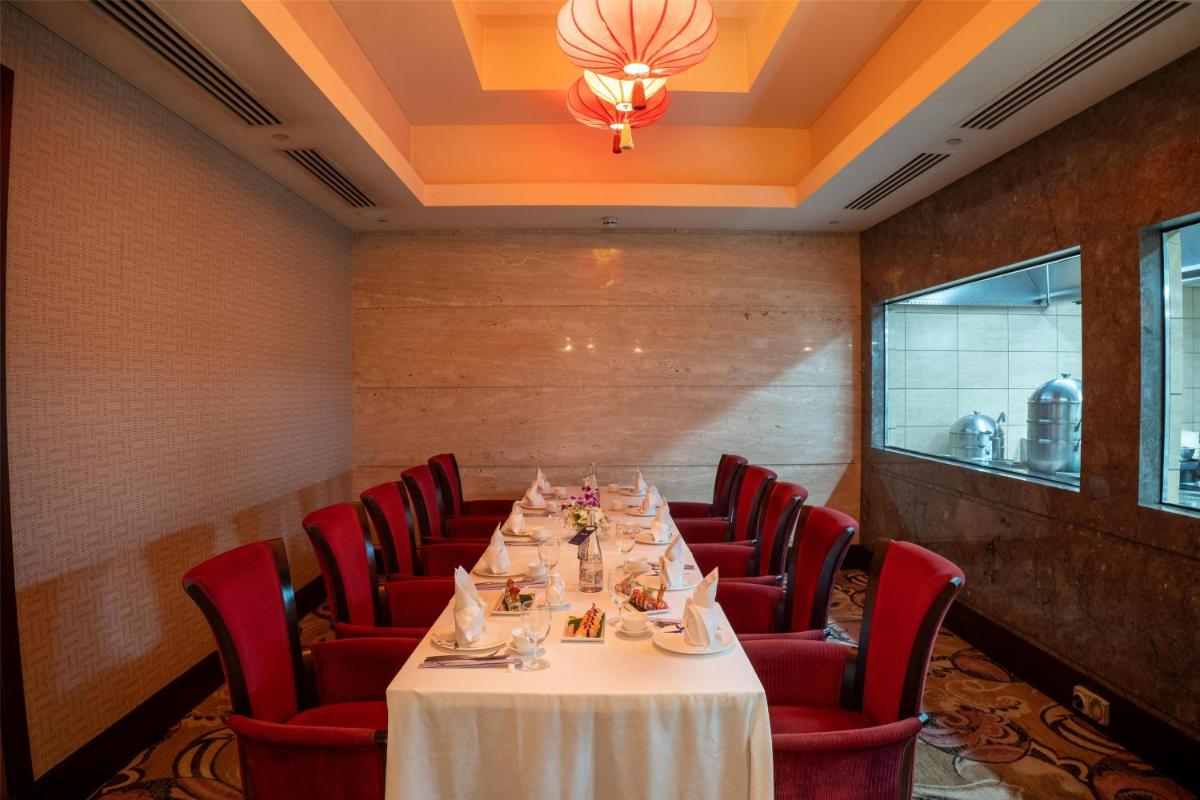 a long table in a room with red chairs at Radisson Blu Hotel, Nagpur in Nagpur