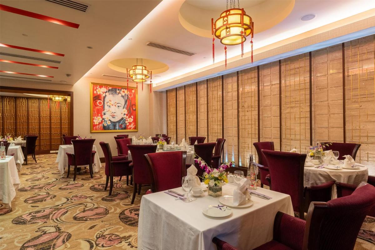 a dining room with tables and chairs and chandeliers at Radisson Blu Hotel, Nagpur in Nagpur