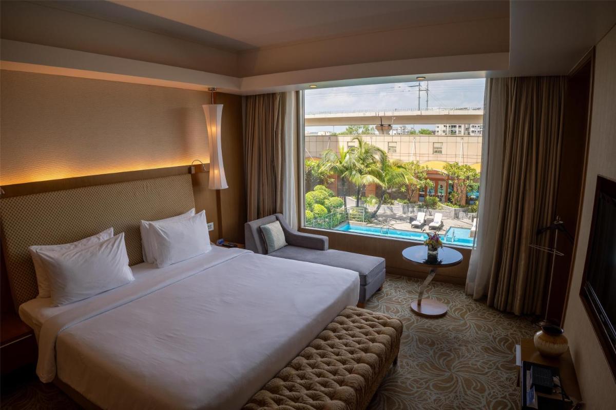 a hotel room with a large bed and a large window at Radisson Blu Hotel, Nagpur in Nagpur