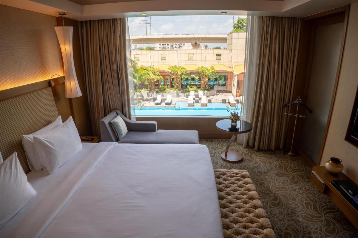a hotel room with a large bed and a window at Radisson Blu Hotel, Nagpur in Nagpur