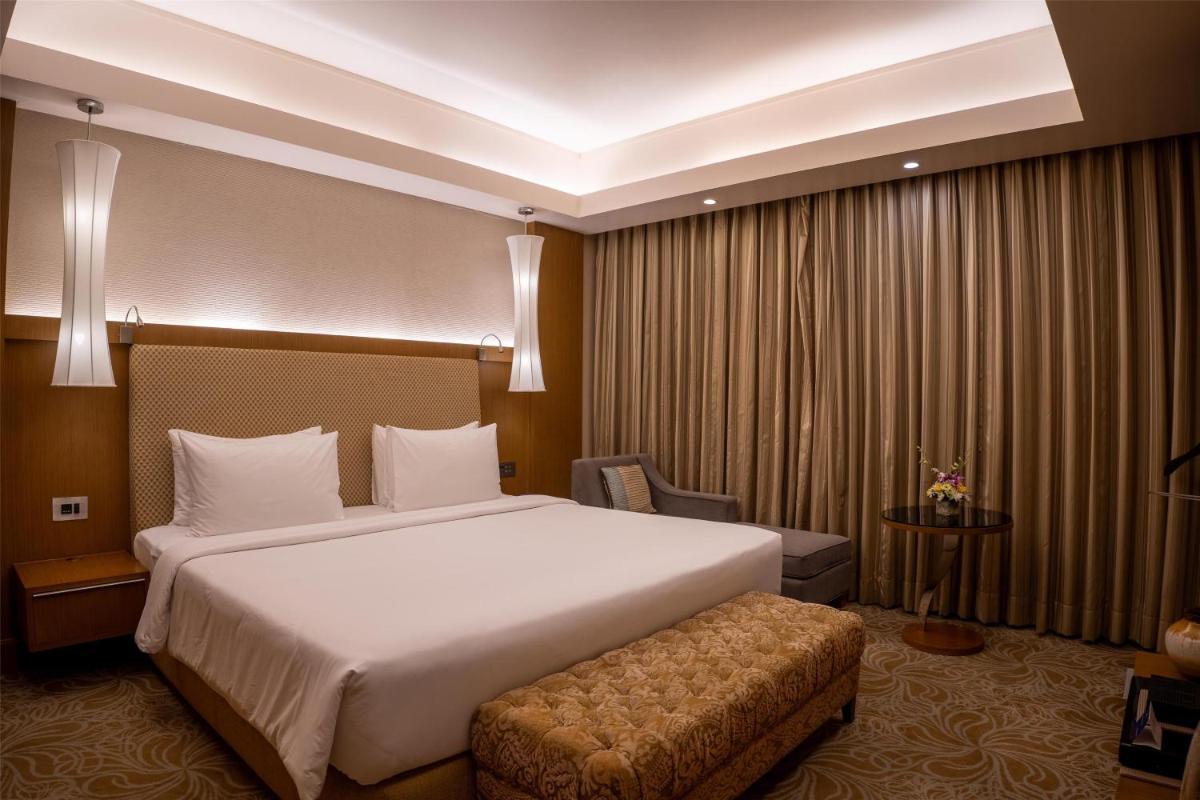 a hotel room with a large bed and a chair at Radisson Blu Hotel, Nagpur in Nagpur