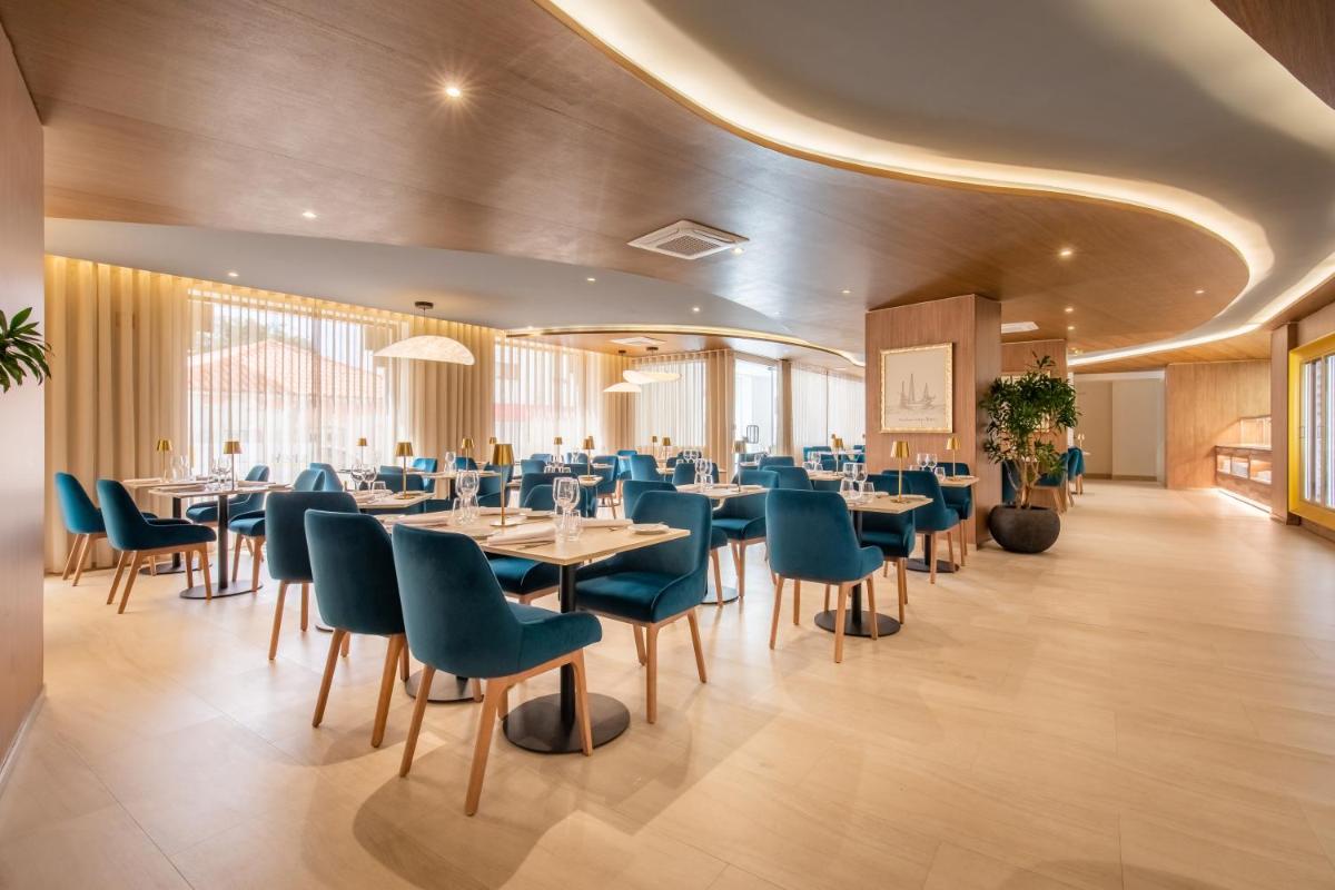 uma sala de jantar com mesas e cadeiras azuis em AP Sines - Costa Alentejana em Sines