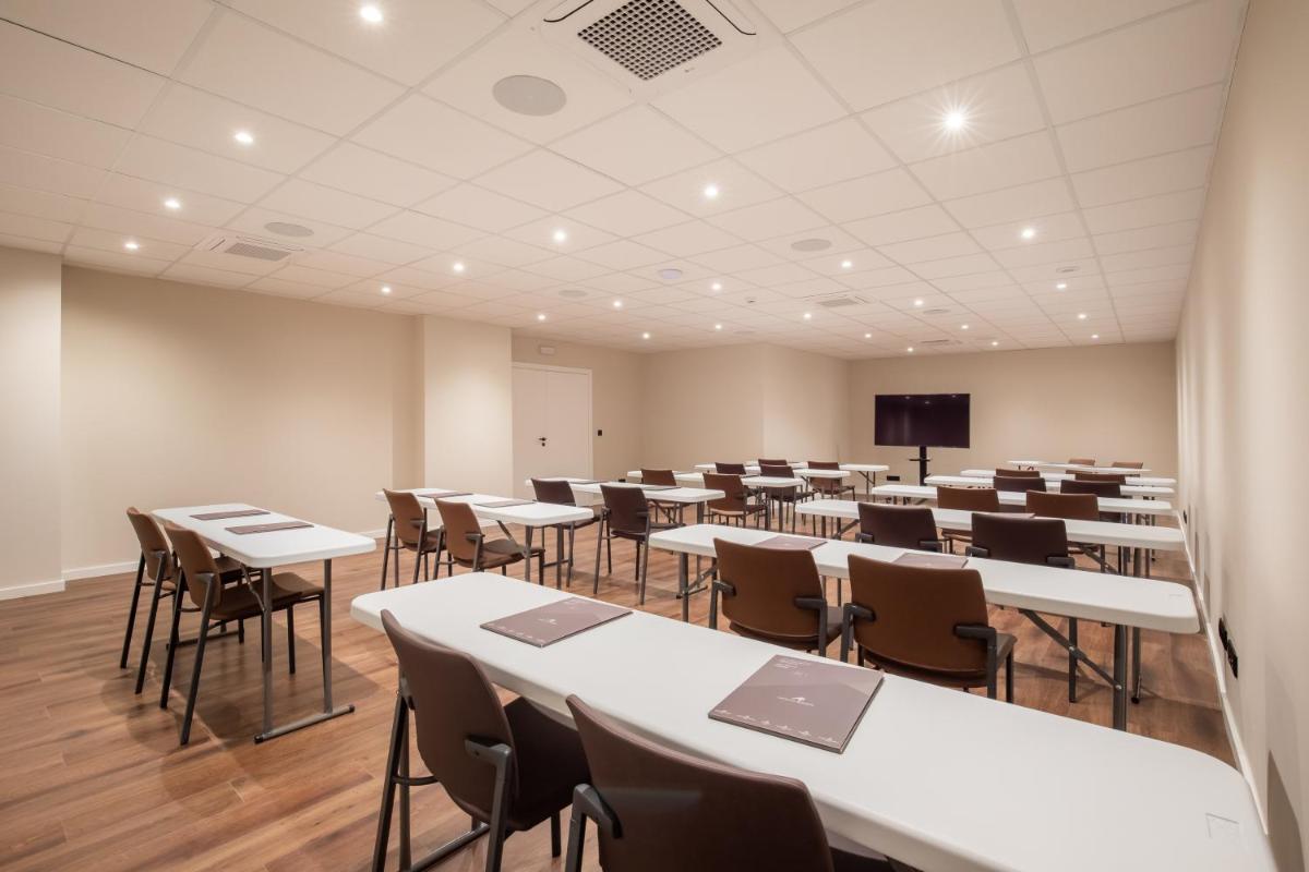 uma sala de conferências com mesas e cadeiras e um ecrã em AP Sines - Costa Alentejana em Sines mais 67 fotografias