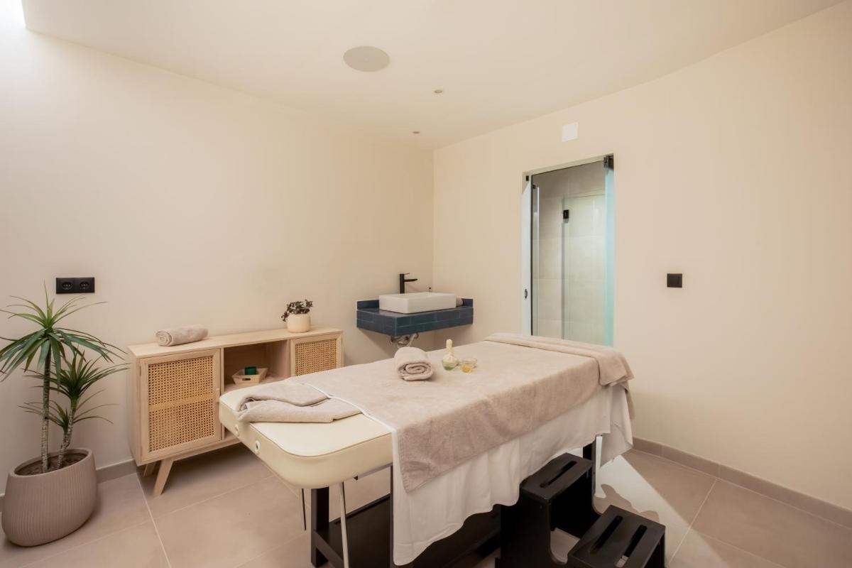 um quarto de hospital com uma cama e um lavatório em AP Sines - Costa Alentejana em Sines