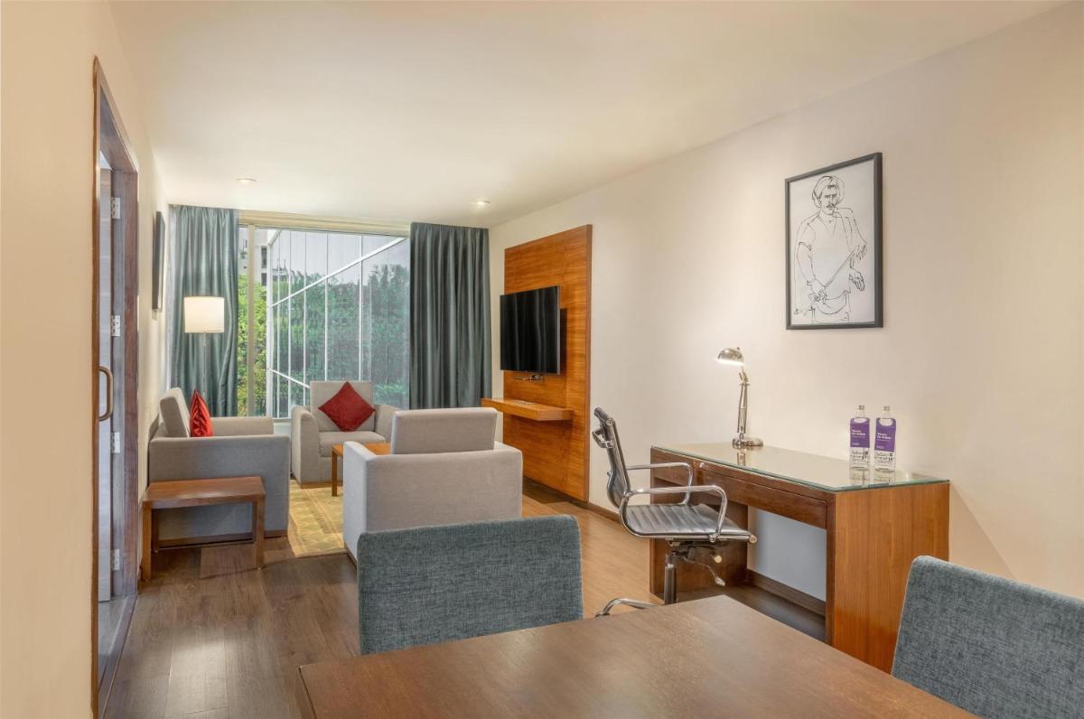 a living room with a table and chairs at Radisson Blu Plaza Hotel Hyderabad Banjara Hills in Hyderabad a living room with a table and chairs at Radisson Blu Plaza Hotel Hyderabad Banjara Hills in Hyderabad