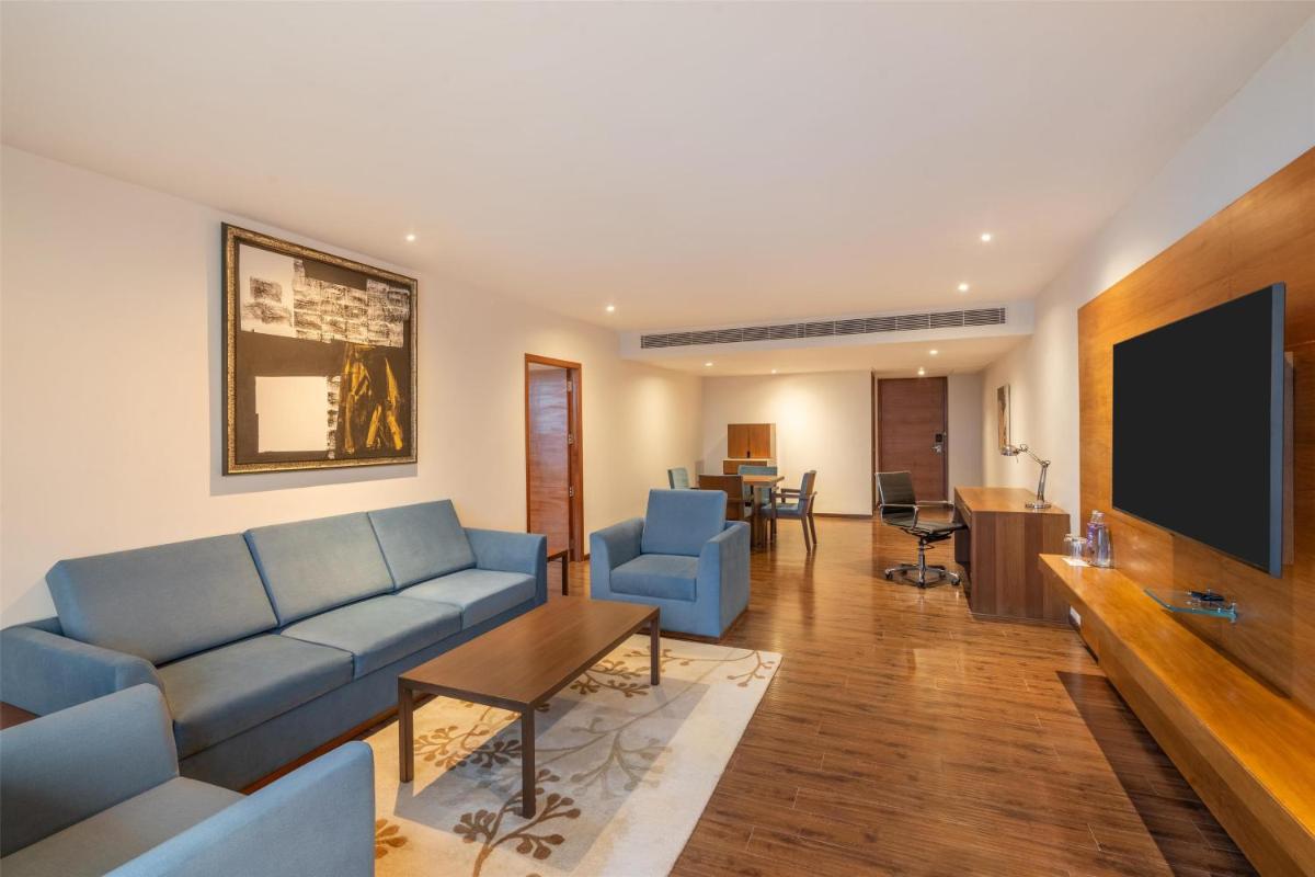 a living room with a couch and a flat screen tv at Radisson Blu Plaza Hotel Hyderabad Banjara Hills in Hyderabad a living room with a couch and a flat screen tv at Radisson Blu Plaza Hotel Hyderabad Banjara Hills in Hyderabad