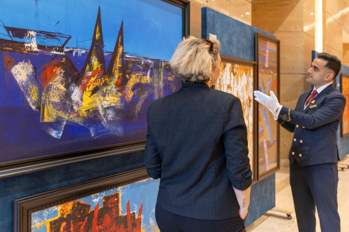 a man and a woman looking at a painting at The Leela Ambience Gurugram Hotel & Residences - The Luxury Urban Sanctuary in Gurgaon