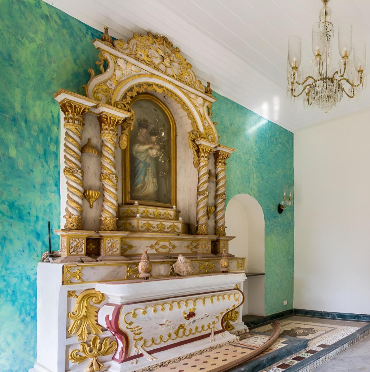 a room with a large golditures in a room with green walls at The Postcard Cuelim, Goa in Cansaulim