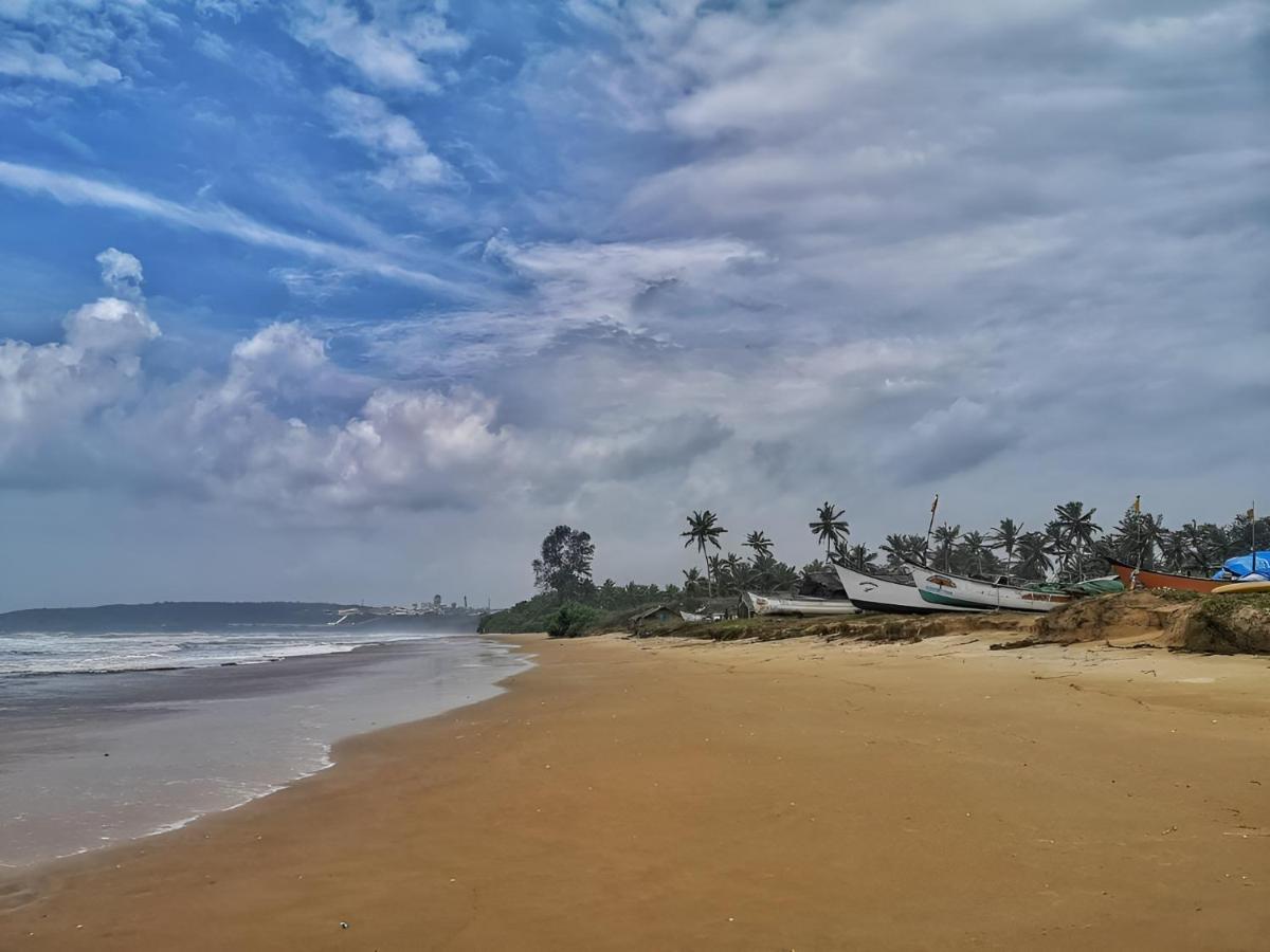 a beach with two boats sitting on the sand at The Postcard Cuelim, Goa in Cansaulim