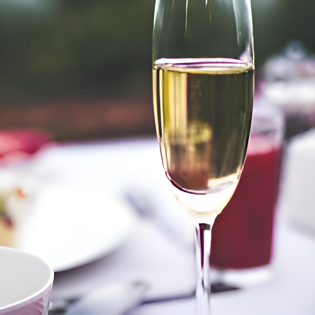 a glass of white wine sitting on a table at The Postcard Cuelim, Goa in Cansaulim